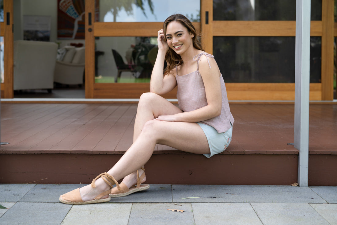 A model sits wearing a Marri camisole and Dawn shorts