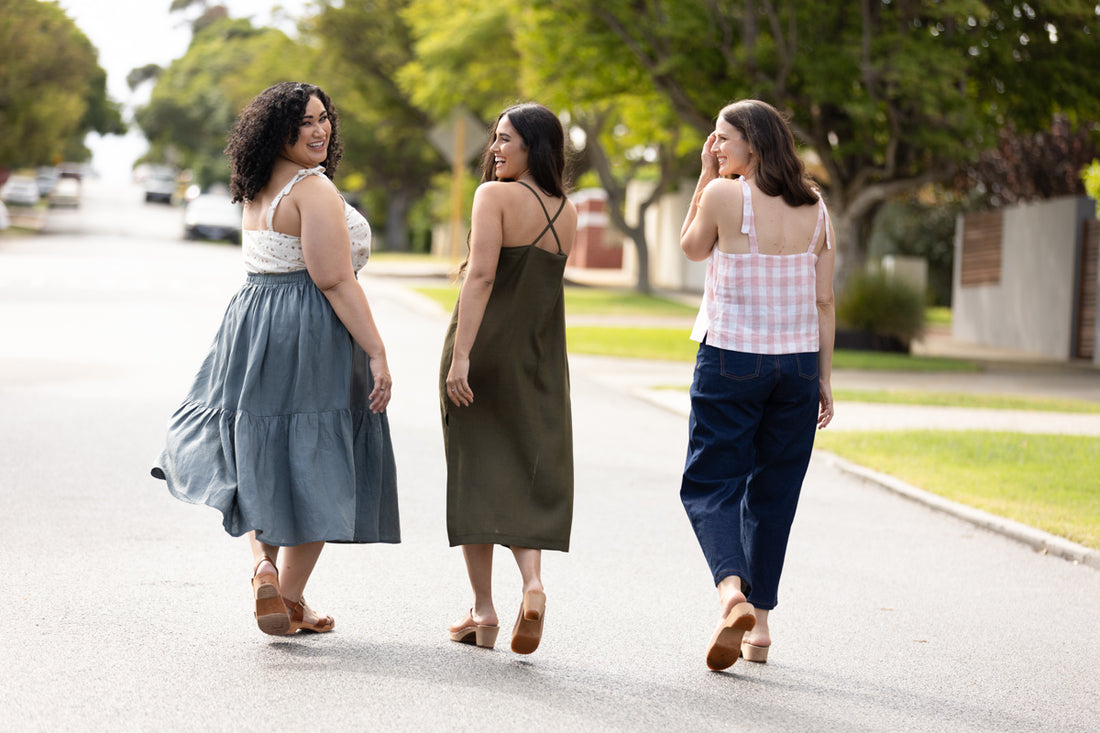 Three models laugh together, two wearing Marri camisoles and one wearing a Marri dress